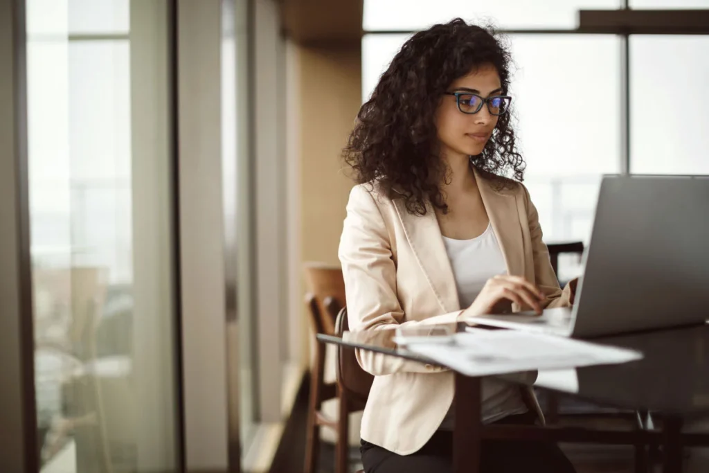 Woman standing at a desk on a laptop
