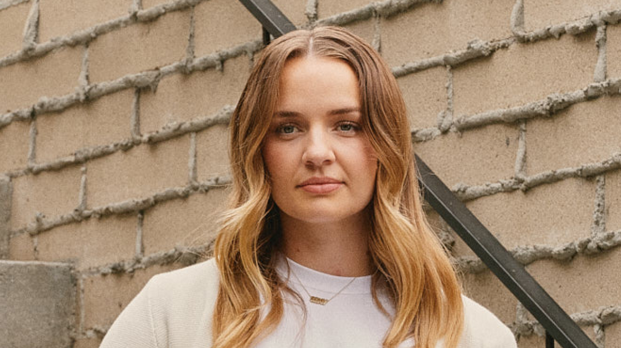 Photo of person standing on stairwell outside.